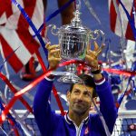 Novak Djokovic of Serbia holds the trophy after defeating Roger Federer of Switzerland in the men's